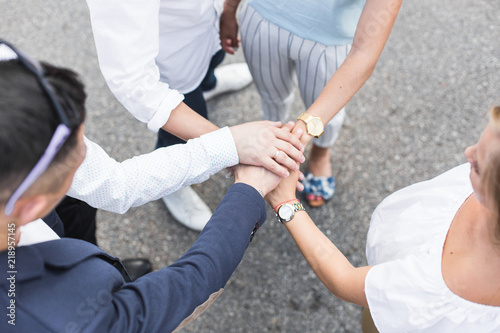 business, people and teamwork concept - smiling group of businesspeople standing in circle and putting hands on top of each other