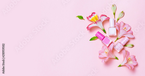 Flowers and nail poloshes composition on pink table © paninastock
