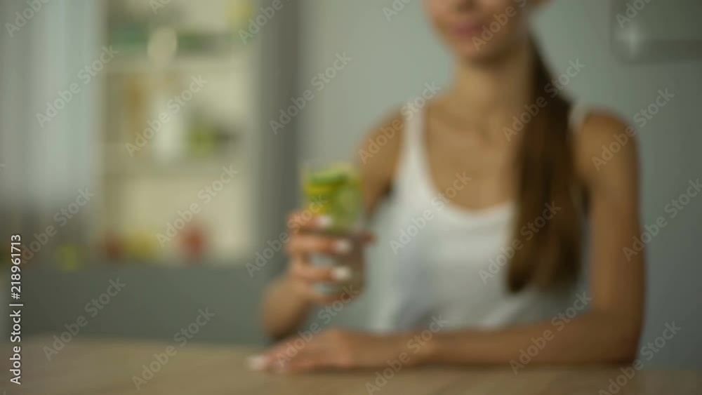Slim girl offers beverage with vegetables for healthy skin, body water balance Slim girl offers beverage with vegetables for healthy skin, body water balance