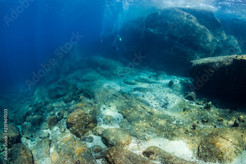 SCUBA divers exploring beautiful underwater scenery in a clear, tropical ocean