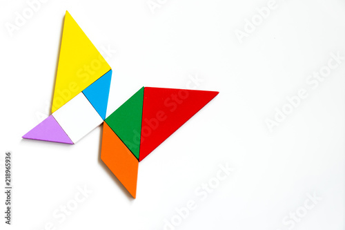 Colorful wood tangram puzzle in butterfly shape on white background