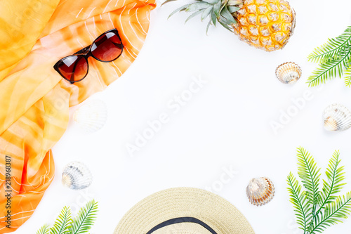 Tropical summer concept with woman fashion accessories, leaves and pineapple on white background. Flat lay, top view