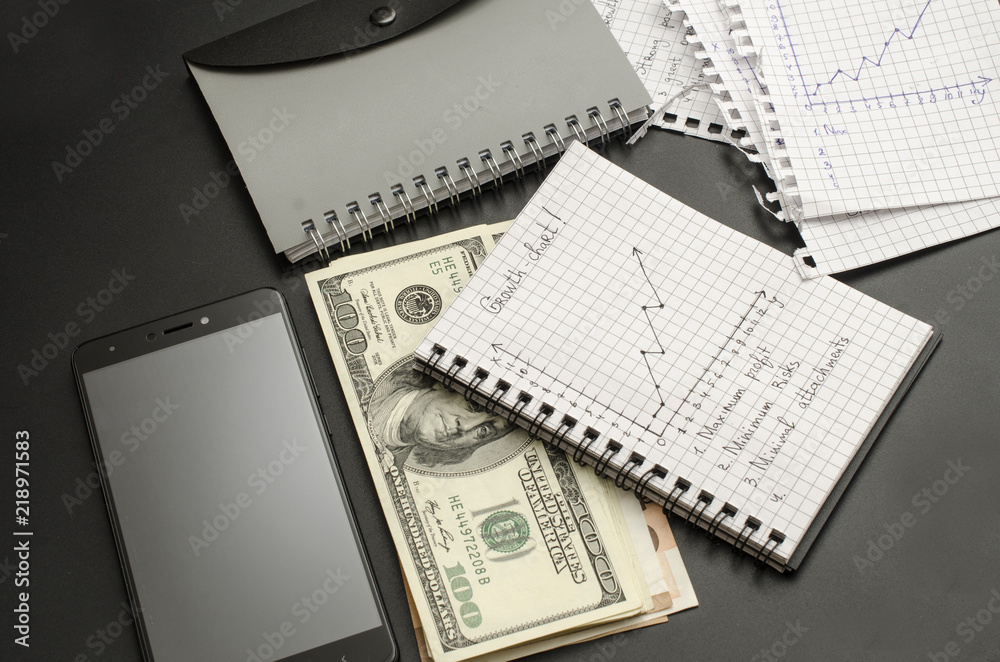 Fototapeta premium notepad with growth chart, pen, money and cellphone