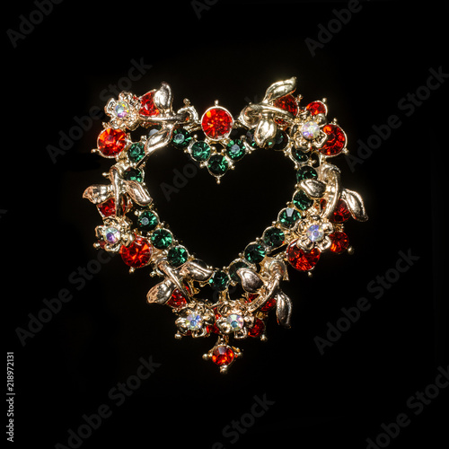 Valokuva gold brooch heart with diamonds isolated on black