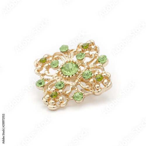 gold brooch with emeralds isolated on white