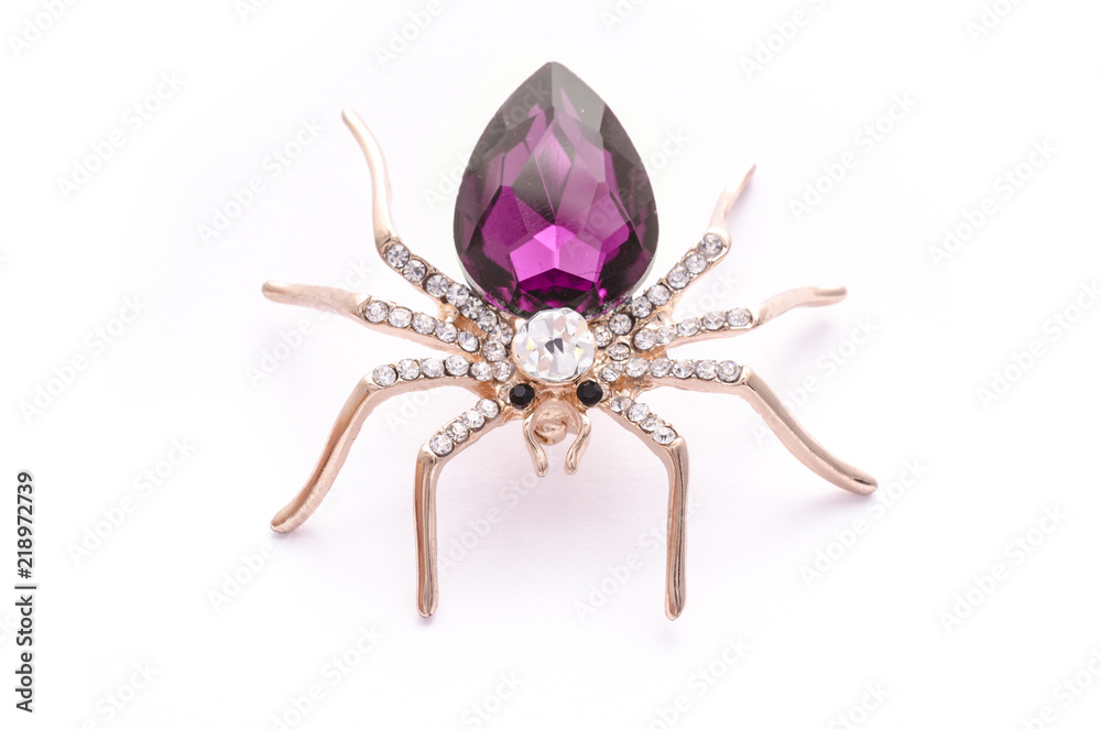 Golden spider with a big crimson stone isolated on white