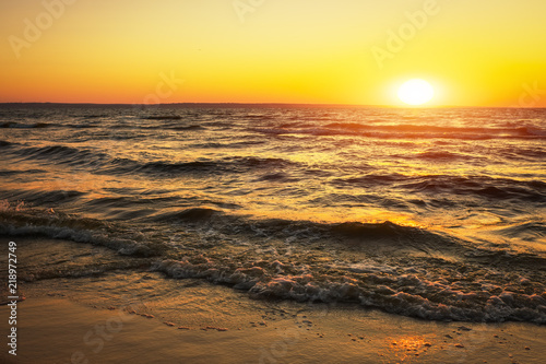 Beautiful landscape with sunset. Colorful sky. Shore of the reservoir  waves.