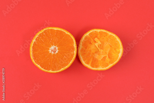 Mandarin Orange Fruit slice half juiced extracted on red background
