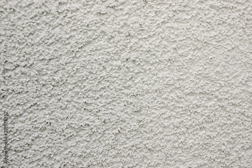 white lime plaster texture wall of a building, wallpaper backdrop , space for text