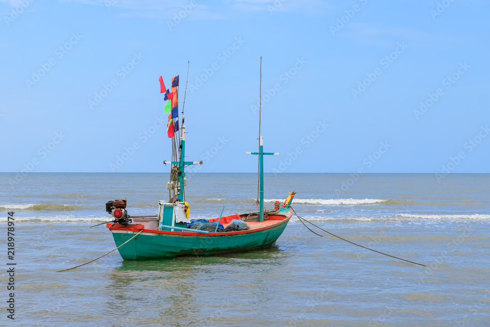 Traditional fishing boat tied with rope in sea near beach