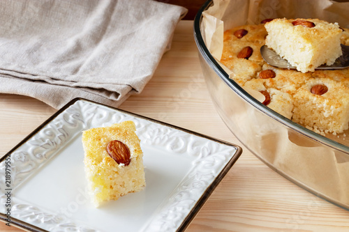 Pieces Basbousa or Namoora traditional arabic sweet dessert with almond. Homemade semolina cake. Selective focus. photo