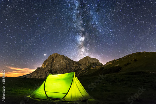 A Camping Tent in the Peak of Mountain with Corno piccolo, Corno Grande and Milky Way Background. In Prati di Tivo - Abruzzo - Italy