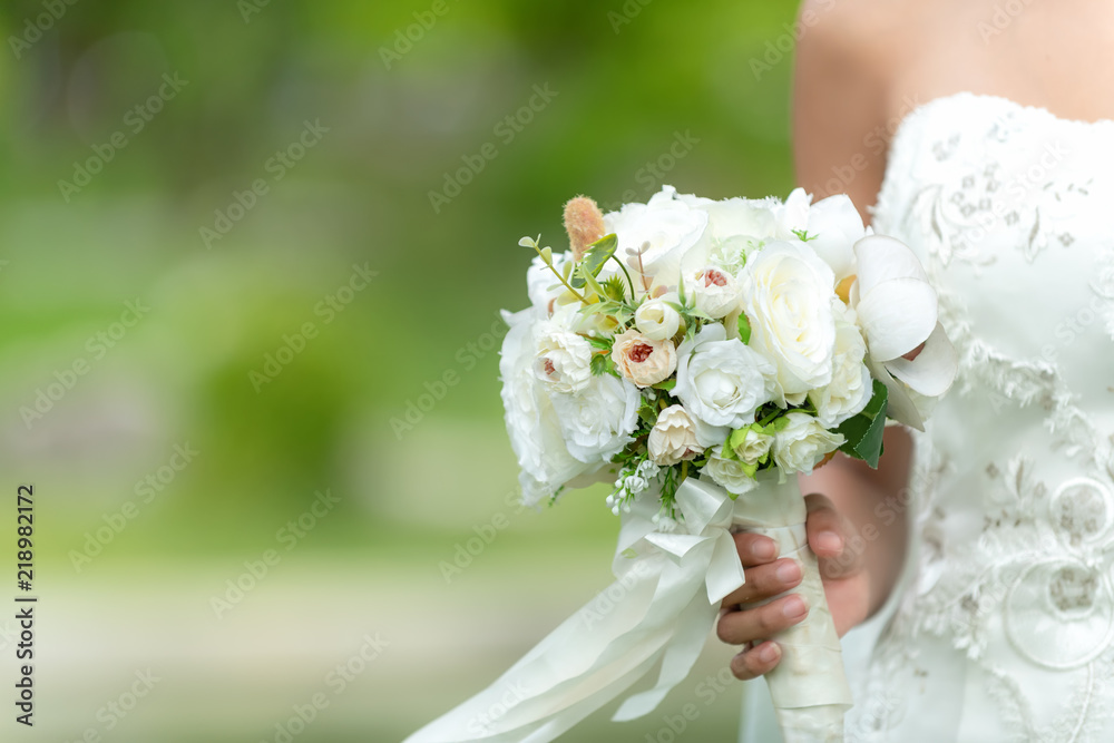 Bride holds a wedding bouquet. Bride wedding white dress in the garden. Nature Background. Bride holds a wedding bouquet. Bride wedding white dress in the garden. Nature Background.