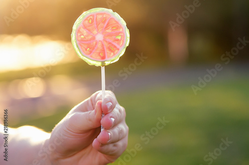 close up lollipop in child hand in park