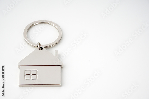 Key and keychain in the shape of a house isolated on white background.