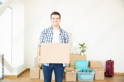 Confident Man Carrying Cardboard Box At Newly Purchased Home