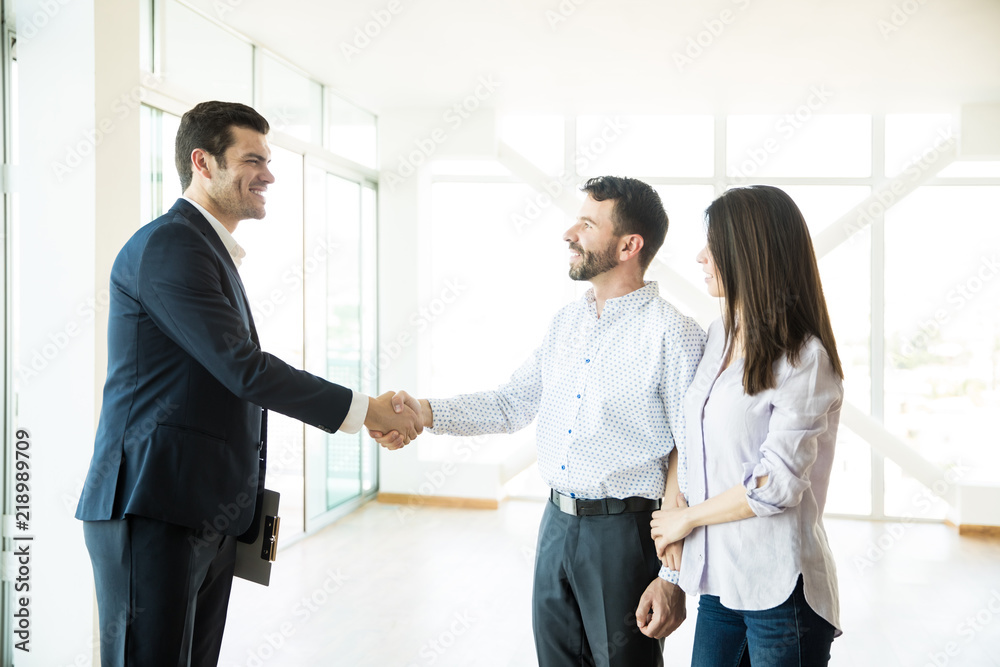Estate Agent Congratulating To Couple For Buying New House