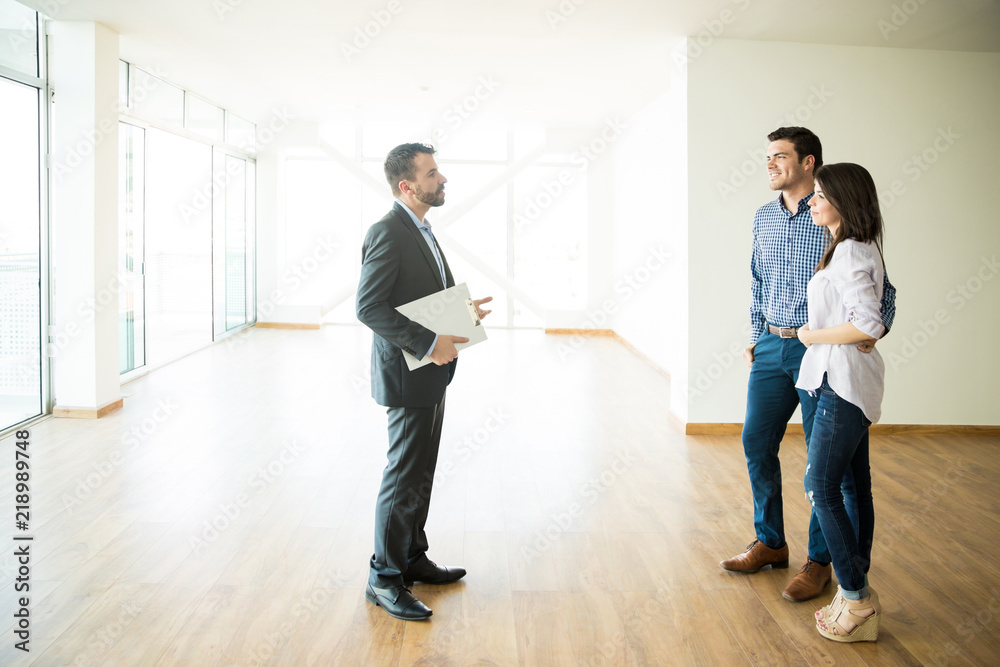 Fototapeta premium Couple With Real Estate Agent Visiting New House