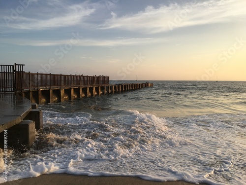 Waves crash against a jetty in Playa Del Rey, California, at sunset.