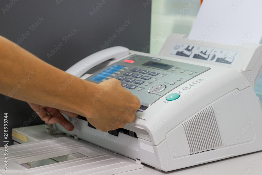 hand man are using a fax machine in the office. Business concept hand man are using a fax machine in the office. Business concept