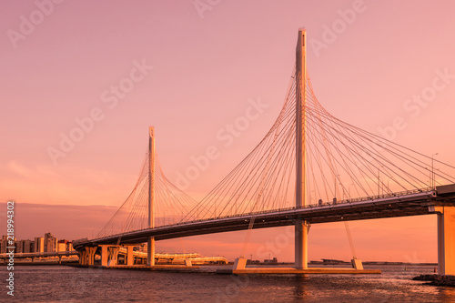 The bridge of circle highway road over Neva river near the mouth of it in the blue hour during the sunset. Evening view on the buildings of Petersburg city and the Finish gulf