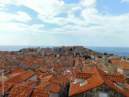 View of Dubrovnik, historic Old Town with buildings and red roofs on the background of the sea, sky, nearby island, Croatia