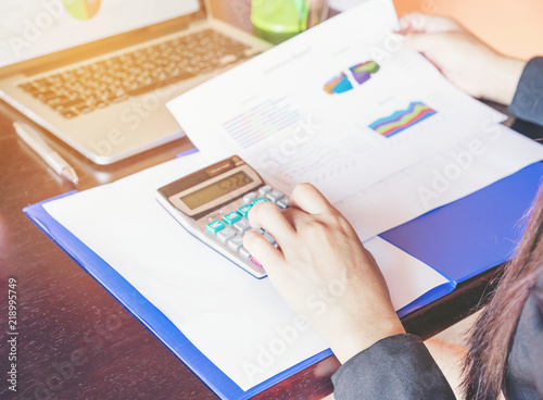 Business women working at the desk with laptop, chart and graph, selective foucs photo