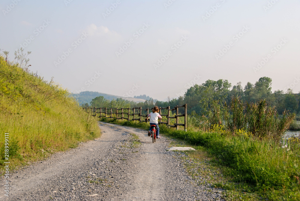 A little girl cycling along a path A little girl cycling along a path