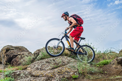Cyclist riding down the rock on a mountain bike  extreme enduro cycling.