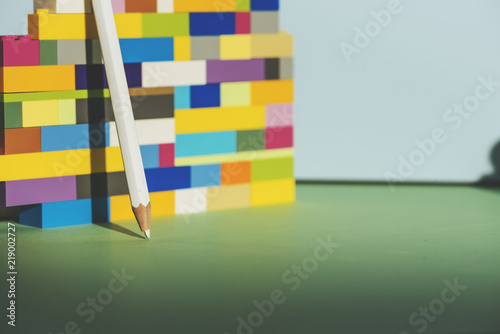 Pencil leaning against the colorful brick Back to school concept © saquizeta