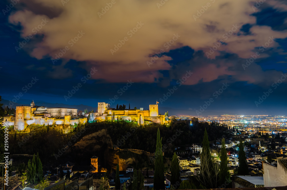 Night cityscape of Granada, Spain, with the Alhambra Palace in the background