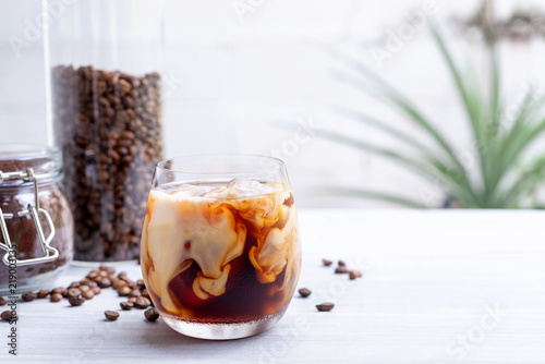 Canvastavla cold brew coffee with milk on white wooden table