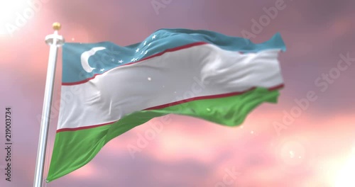 Uzbekistan flag waving at wind in slow at sunset, loop photo