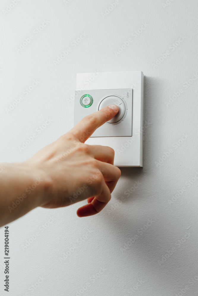 hand turning knob on thermostat climate control hand turning knob on thermostat climate control
