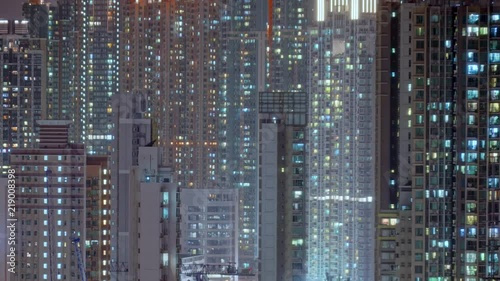 Day to night transition timelapse of Hong Kong apartment buildings. Chinese crowded city with lights turning on and off at midnight. Fast paced modern Asian night-scape time lapse in urban metropolis.
