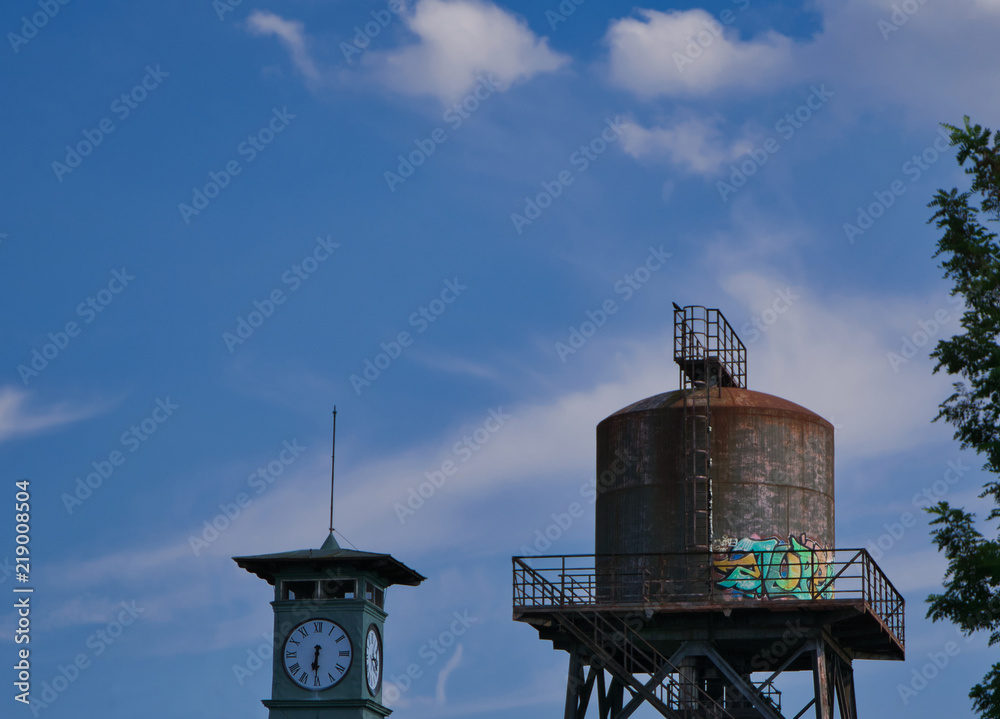 Alter Wasserturm mit einem Uhrturm im Vordergrund Alter Wasserturm mit einem Uhrturm im Vordergrund