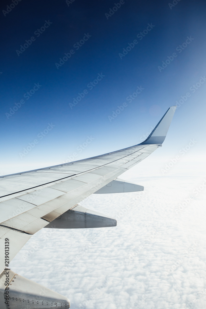 airplane wing against clouds and blue sky background airplane wing against clouds and blue sky background