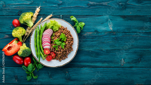 Lentil with radish, cherry tomatoes, beans and vegetables. Healthy food. On a blue wooden table. Top view. Free space for text.