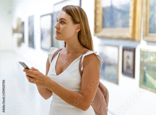 Woman using smartphone in museum