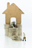 Miniature people: Businessman looking for housing for the future. Image use for home for family.