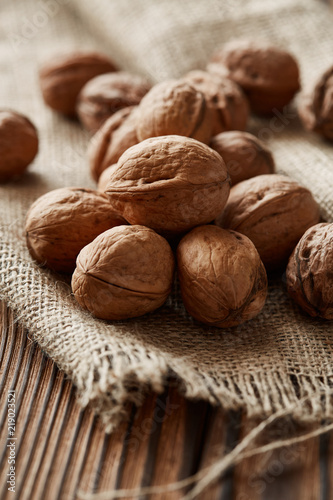 Walnuts and kernels with burlap fabric on a dark rusty wood backdrop