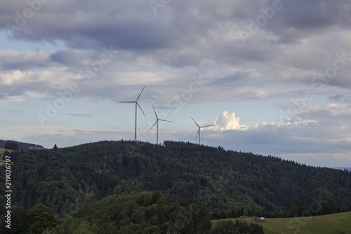 Wind turbines on wooded mountains near Gersbach in the Black Forest in the light of the evening sun