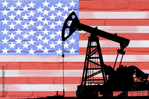 silhouette of oil drilling pump on background of united states flag.