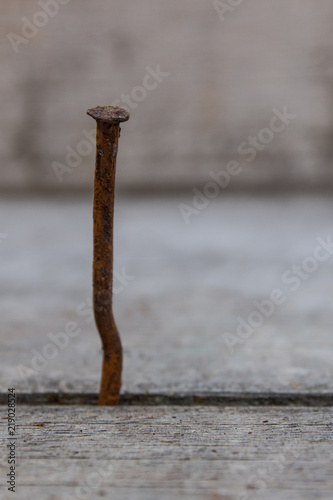 Single old rusty wonky and bent nail 