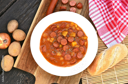 Potato goulash with Debreziner sausage or German name is Kartoffelgulasch mit Debreziner on wooden background