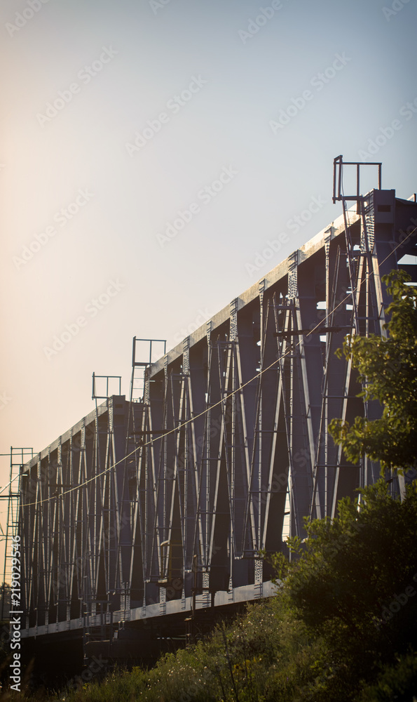 Obraz premium railway bridge of steel structures, on a sunset background