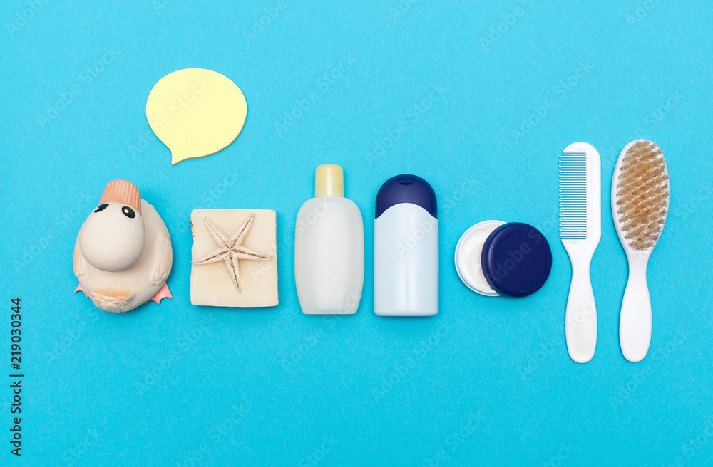 Obraz premium Free space for text, mock-up. Organic cosmetics for shower, Flat lay bathroom stuff.Top view of handmade baby soaps, yellow rubber duck, bottle with shampoo, body oil, cream, comb and loofah