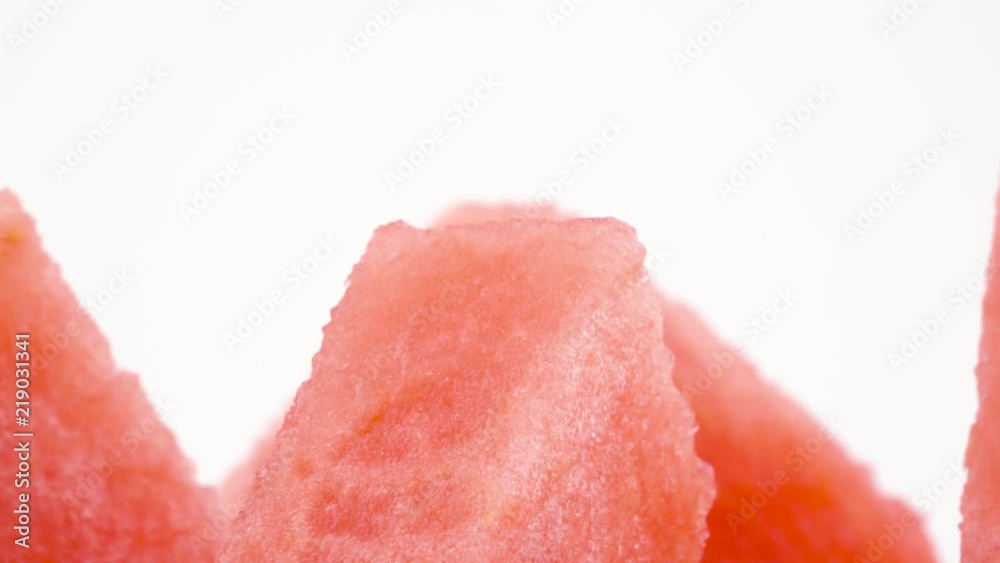 Macro shooting of upper part of ripe watermelon slices. Cross section. Slowly rotating on the turntable isolated on the white background. Close-up. Macro shooting of upper part of ripe watermelon slices. Cross section. Slowly rotating on the turntable isolated on the white background. Close-up.