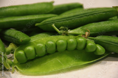Fresh green peas in pods on white background - healthy food, subsistence farming, agriculture, vegetable growing