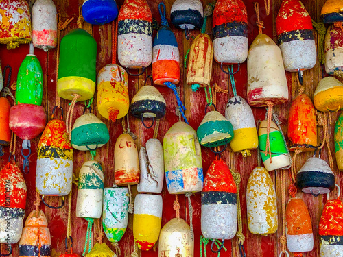 Wooden wall covered with many colorful buoys